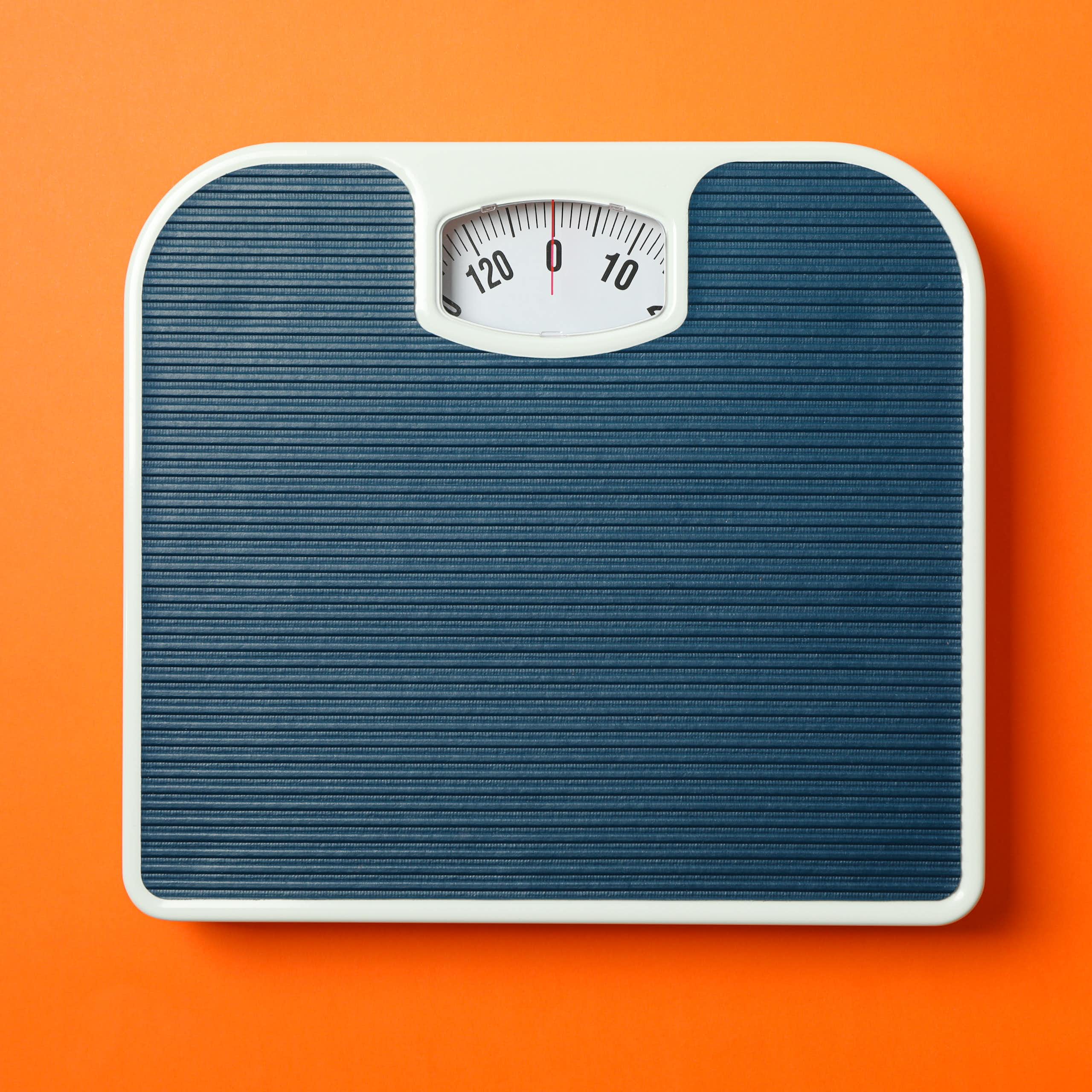 Une balance grise sur un fond orange