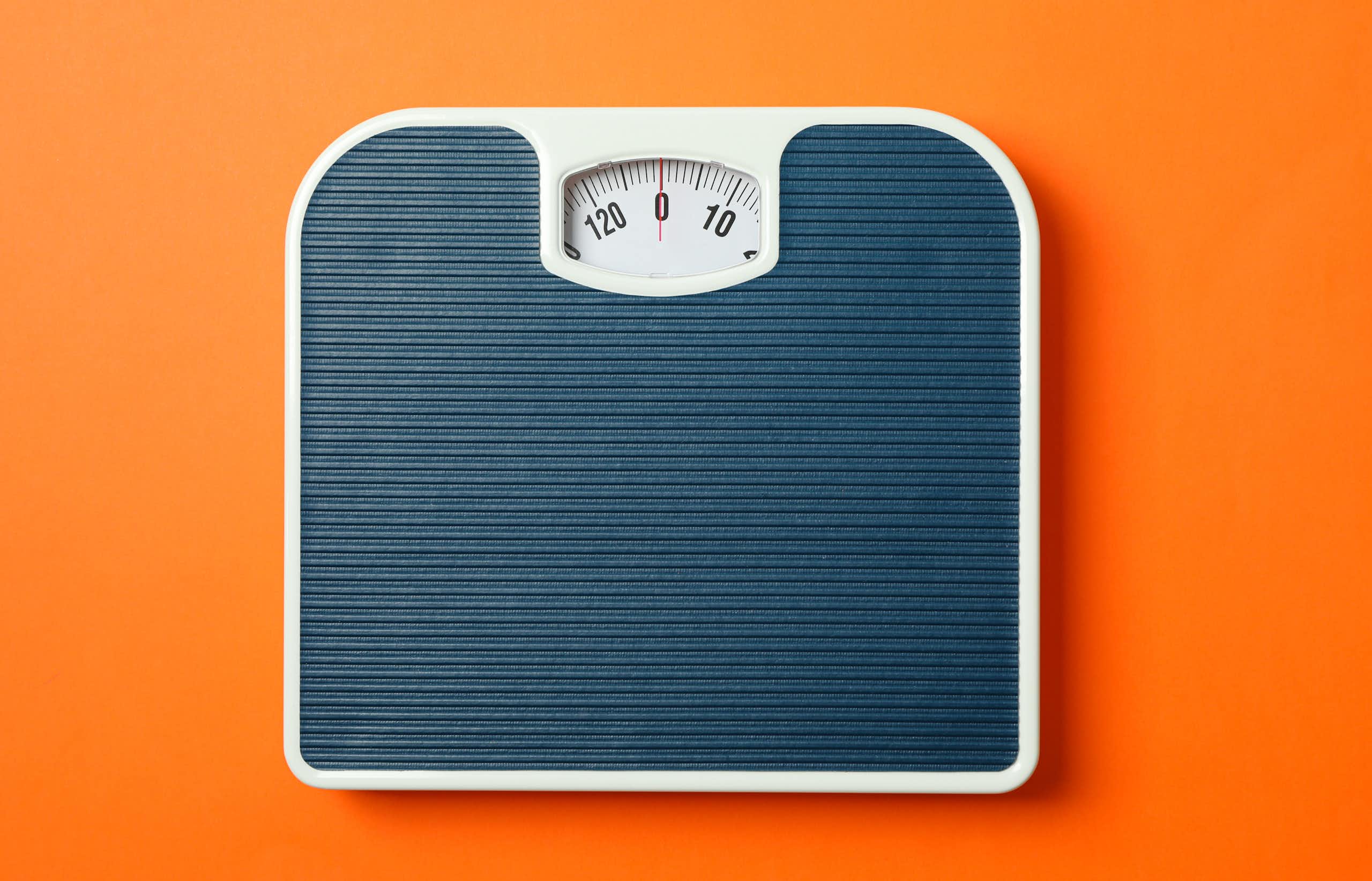 Une balance grise sur un fond orange