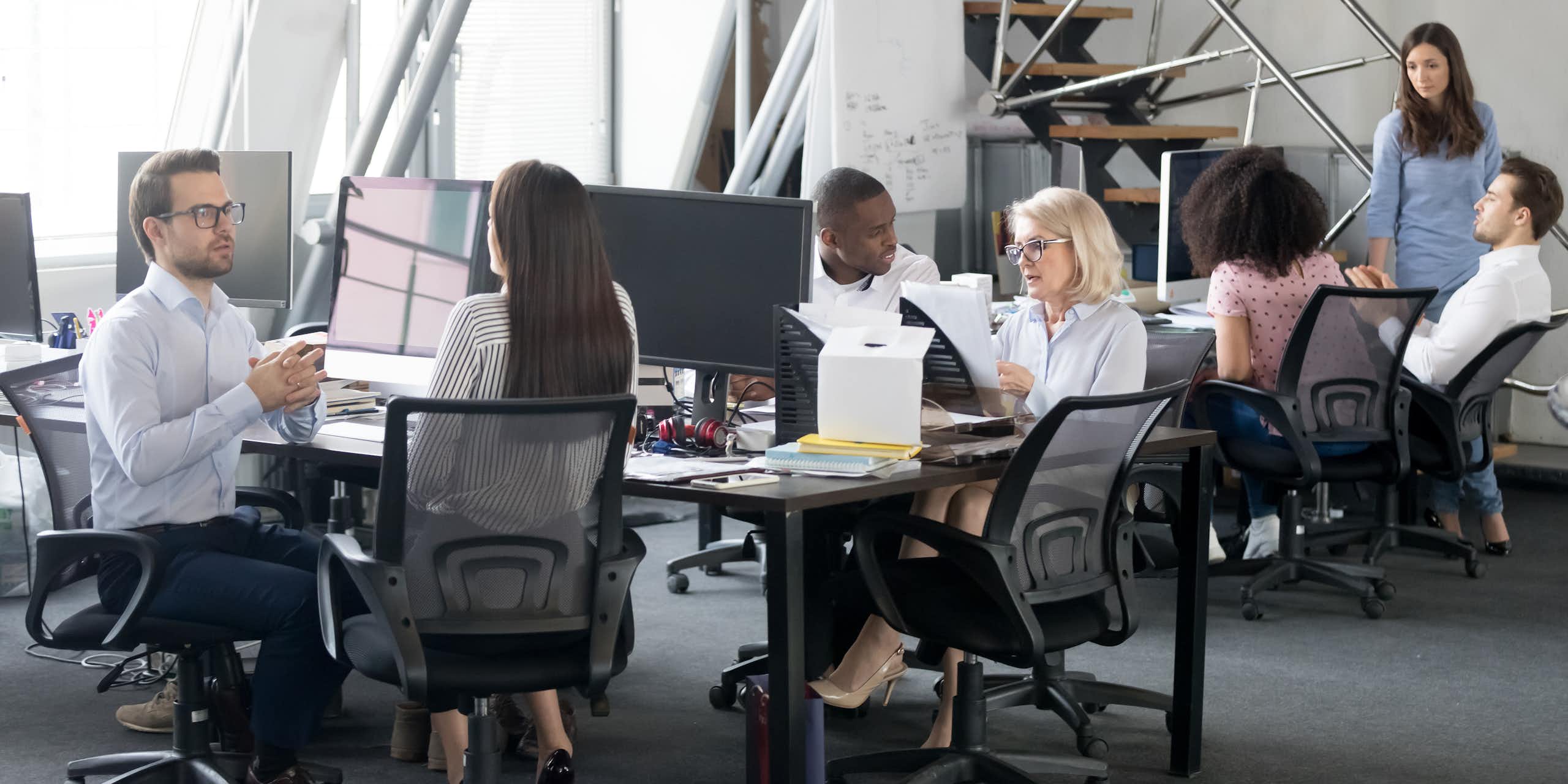 Vue d'un bureau avec des personnes assises, en train d'échanger