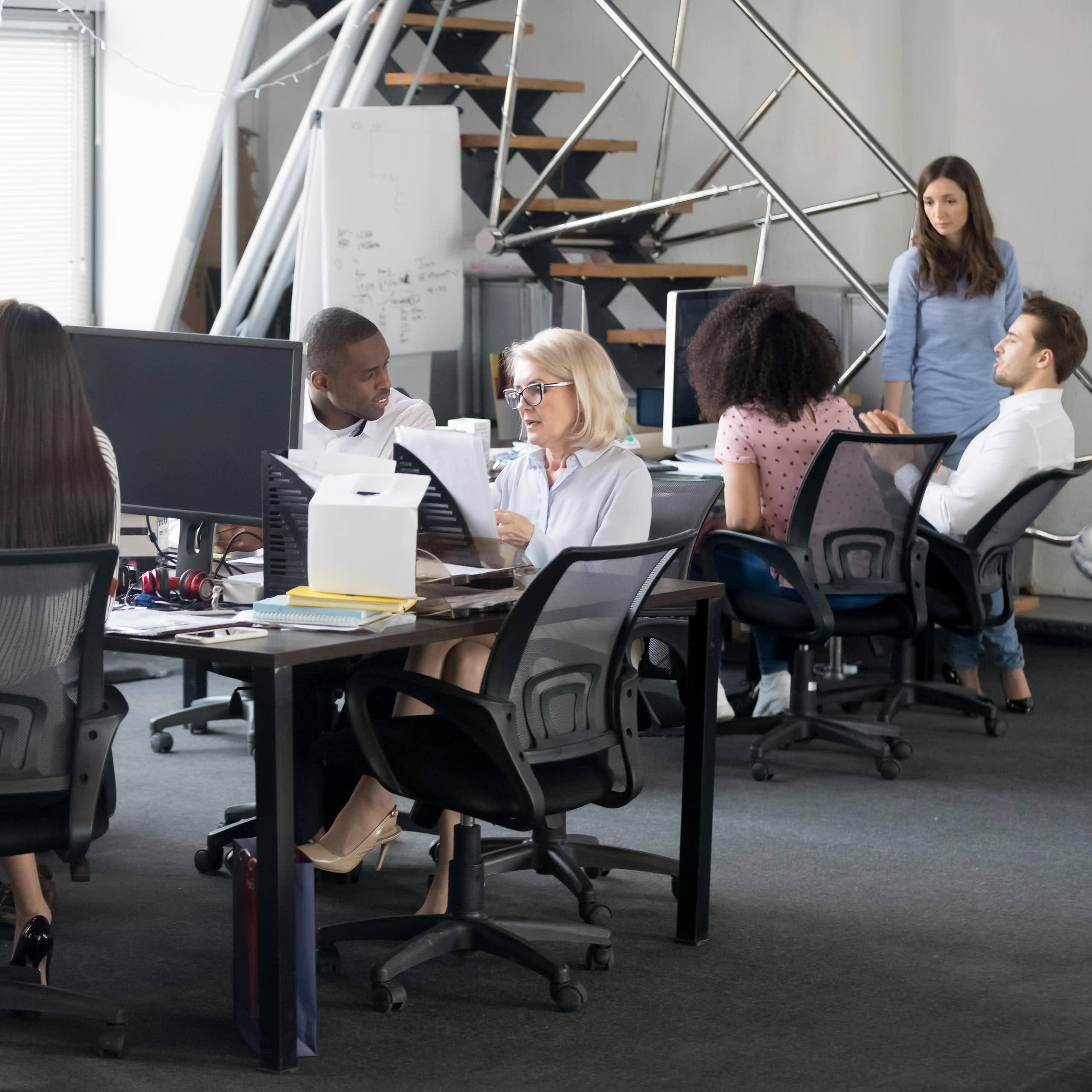 Vue d'un bureau avec des personnes assises, en train d'échanger
