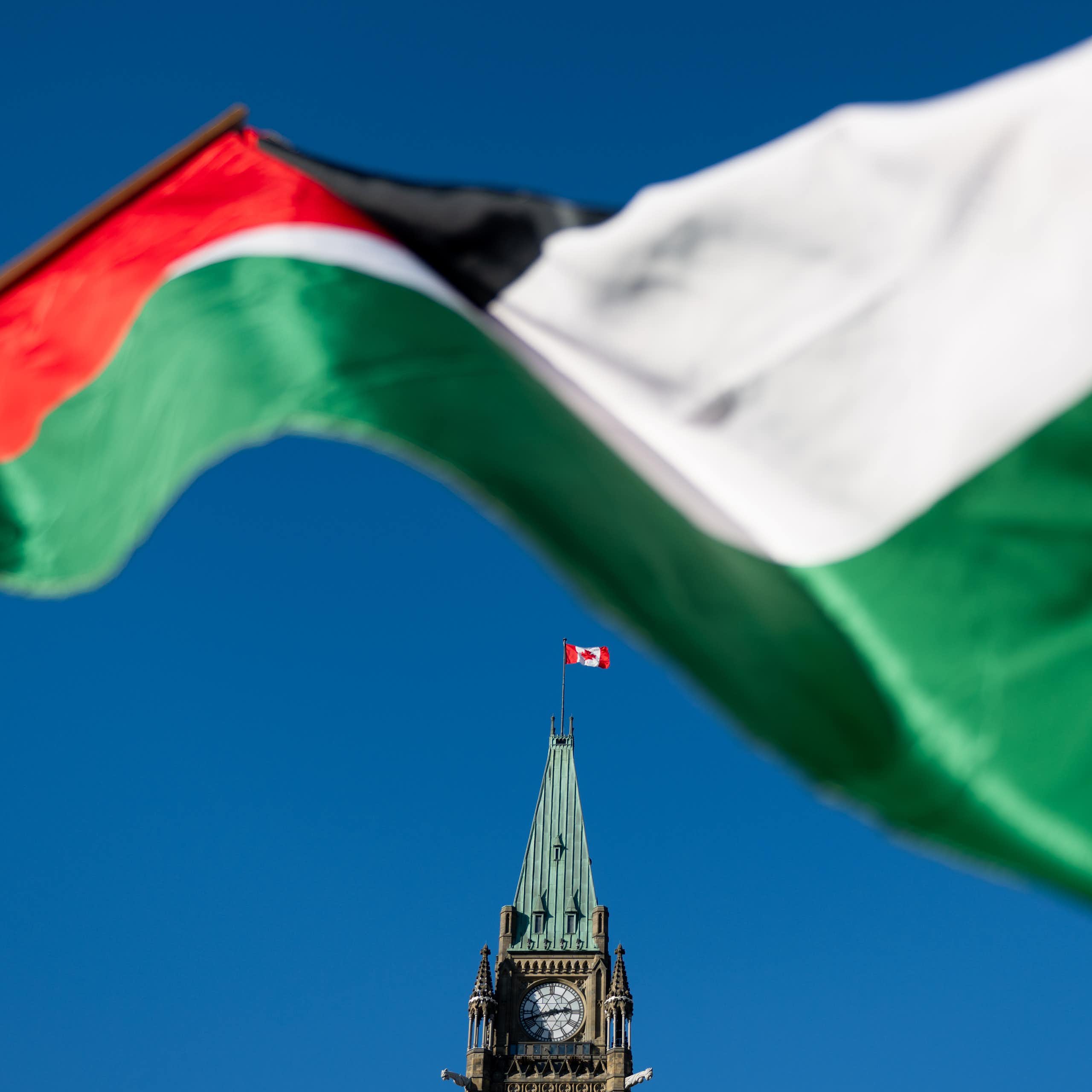 A green white and red flag frames the Peace Tower.