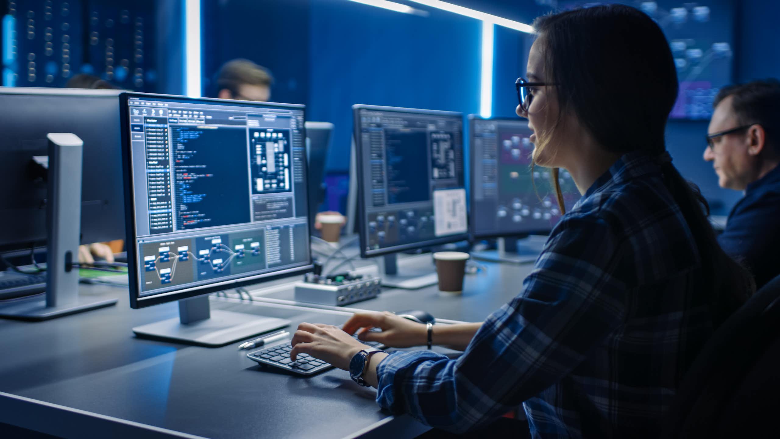 Une femme en train de coder, face à un ordinateur