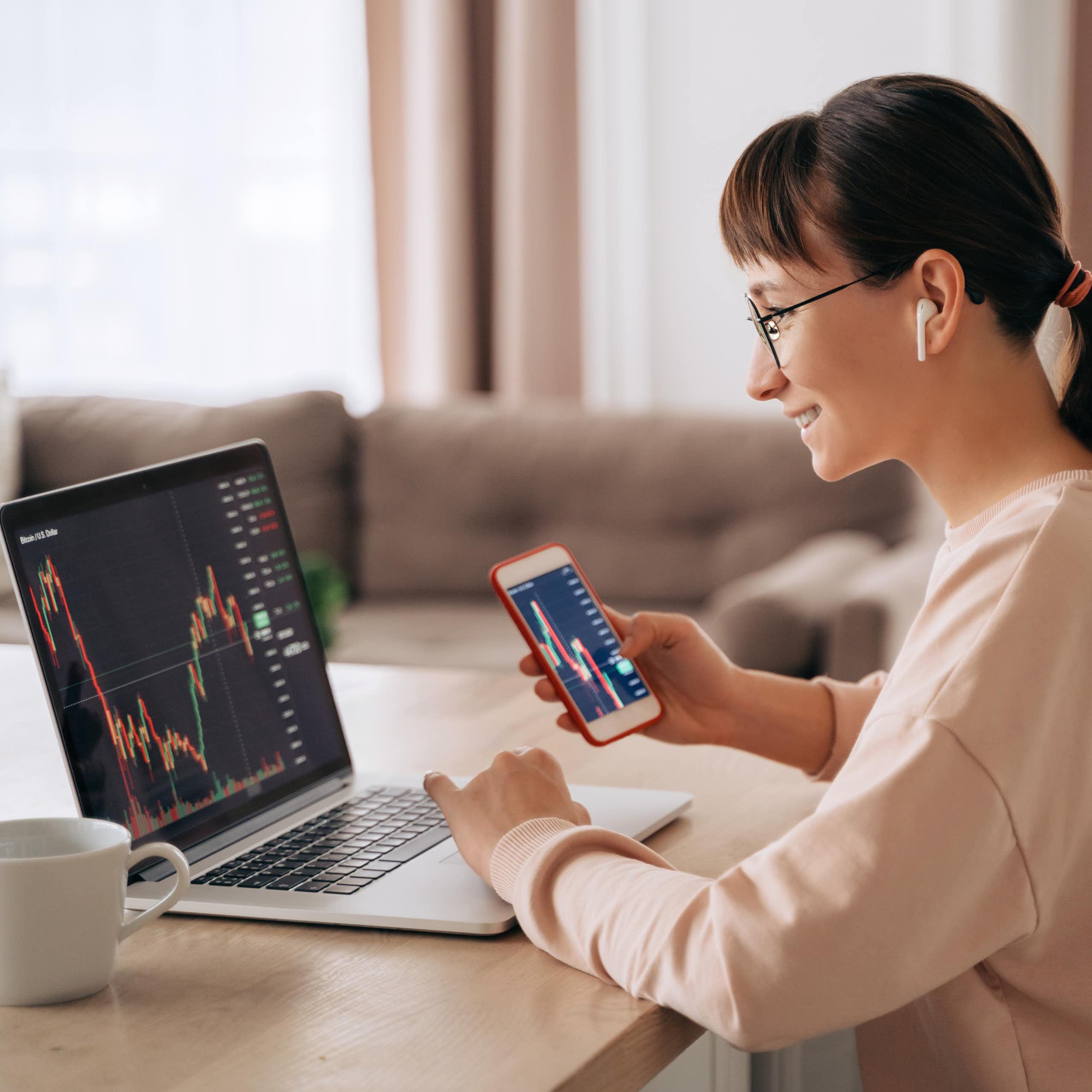 A young woman looking at stock information on a laptop