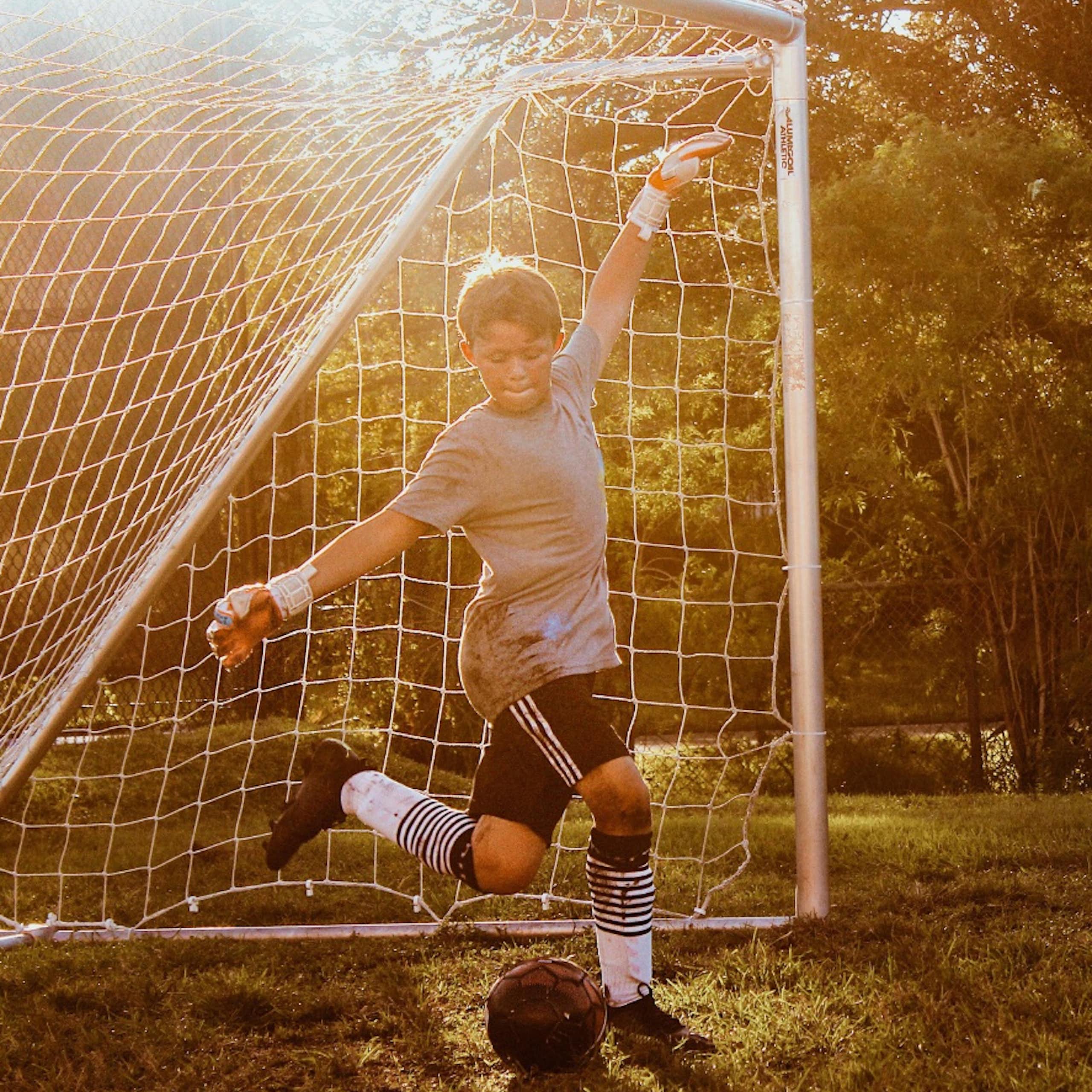 A boy playing soccer and a woman dancing