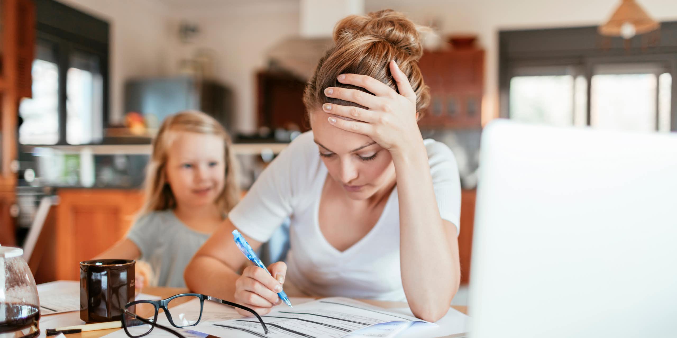 Une mère fatiguée télétravail avec une enfant derrière elle