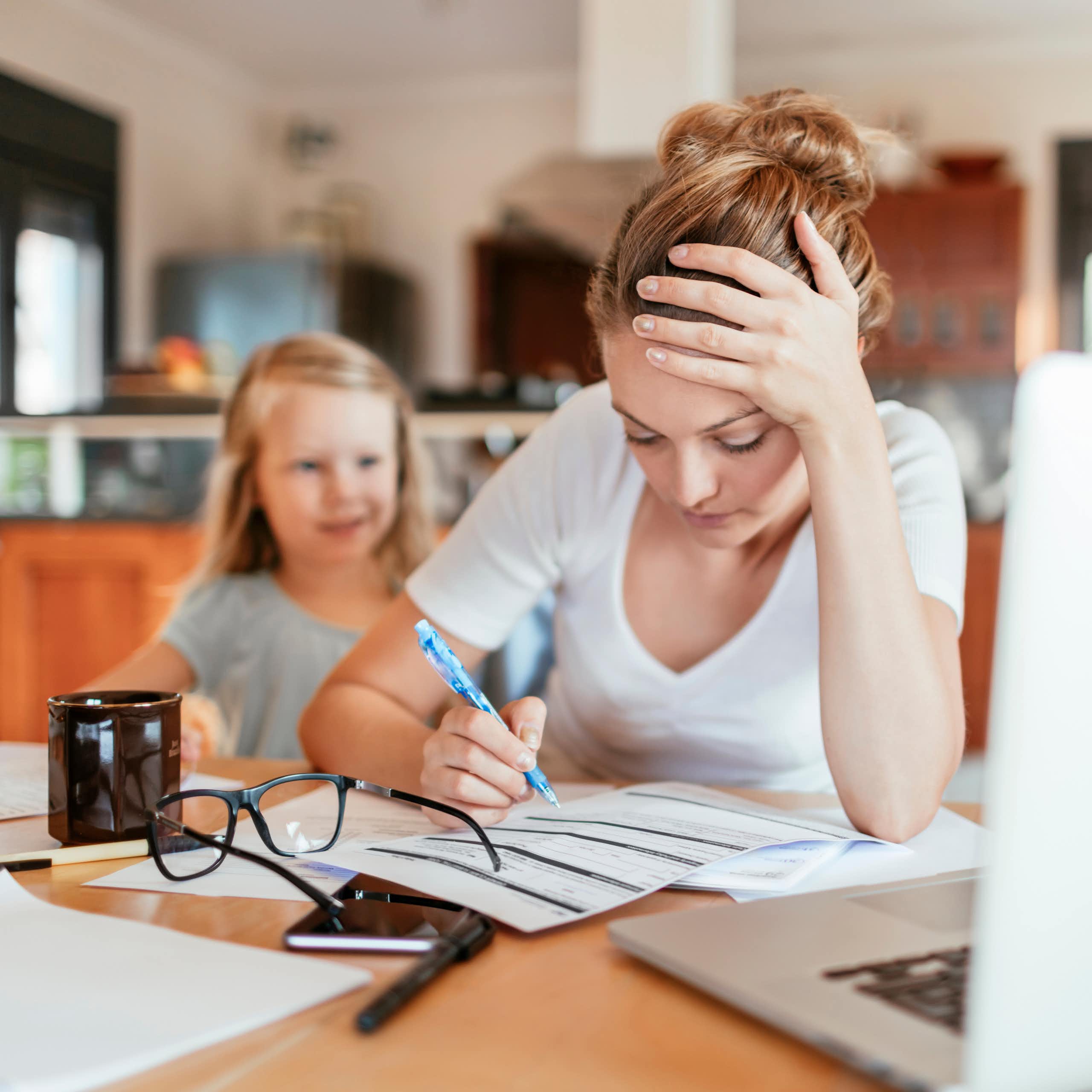 Une mère fatiguée télétravail avec une enfant derrière elle
