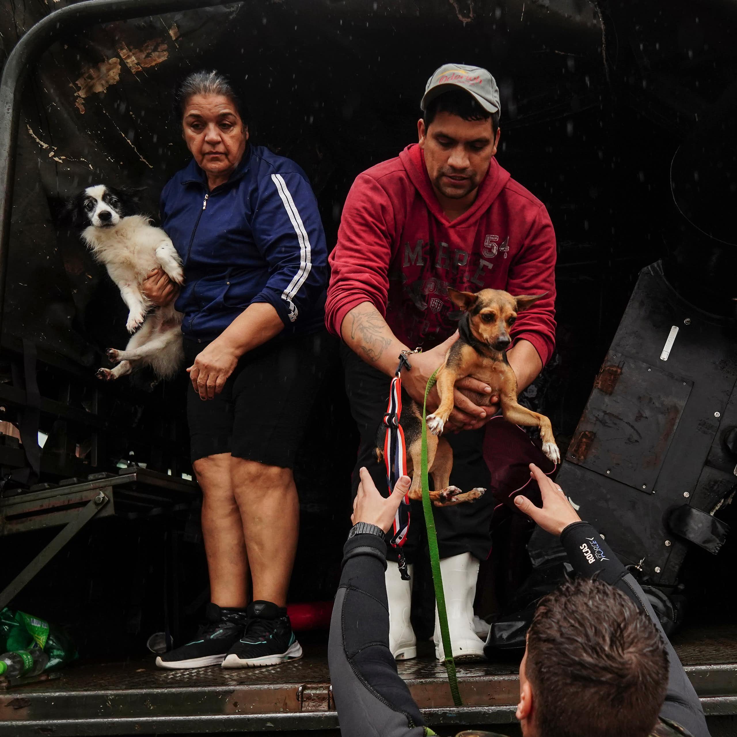 People and their pets evacuate a flooded area after heavy rain in Sao Sebastiao do Cai, Rio Grande do Sul state