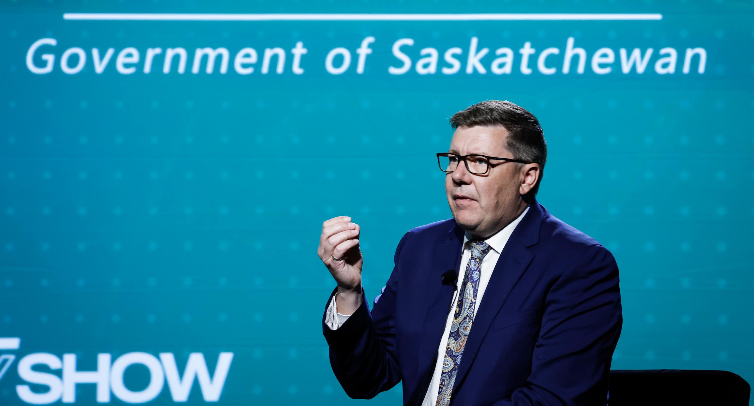 A man in a suit speaking at a podium.