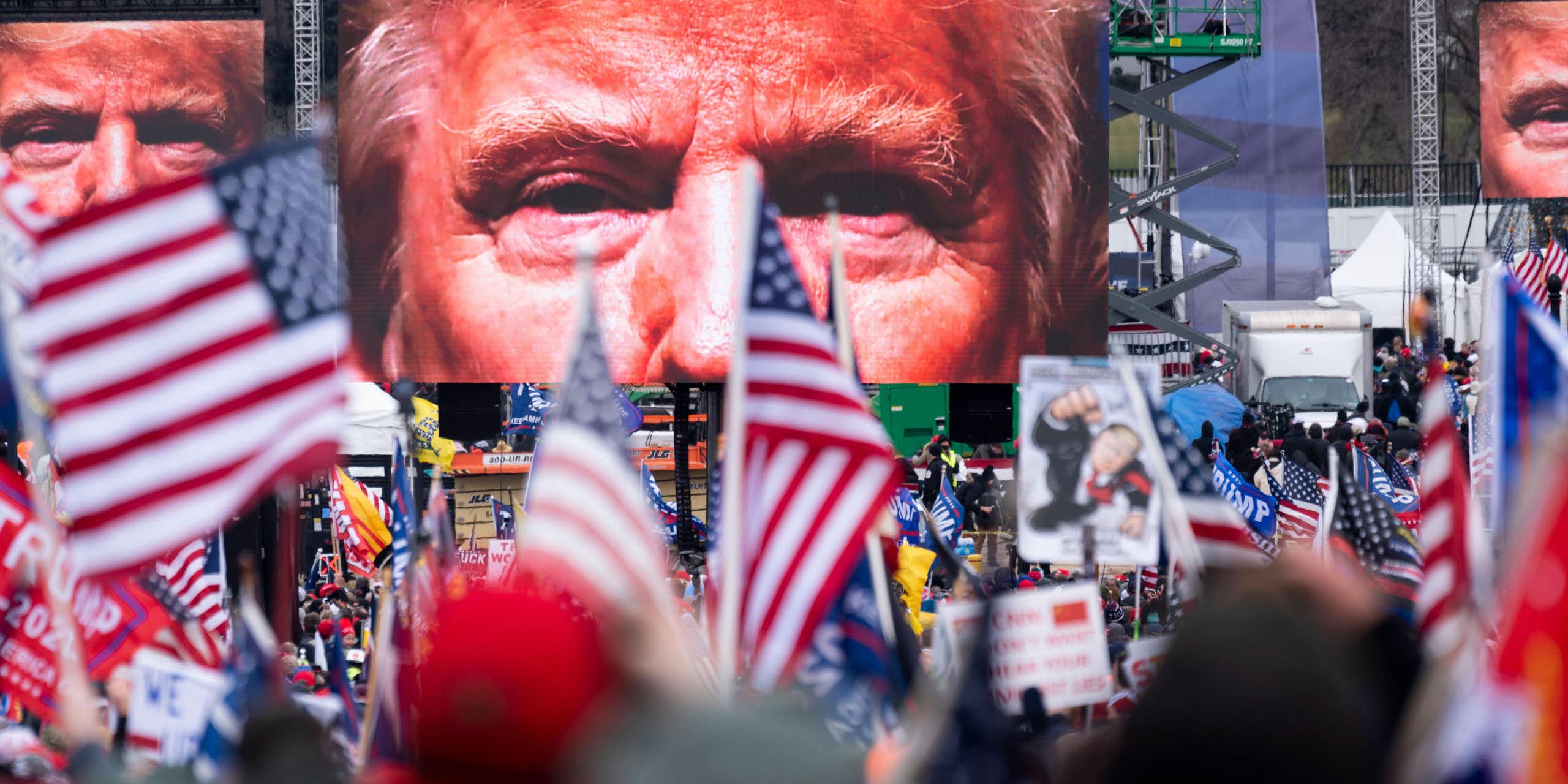 Trump supporters watch him on a big screen on January 6 2021. 