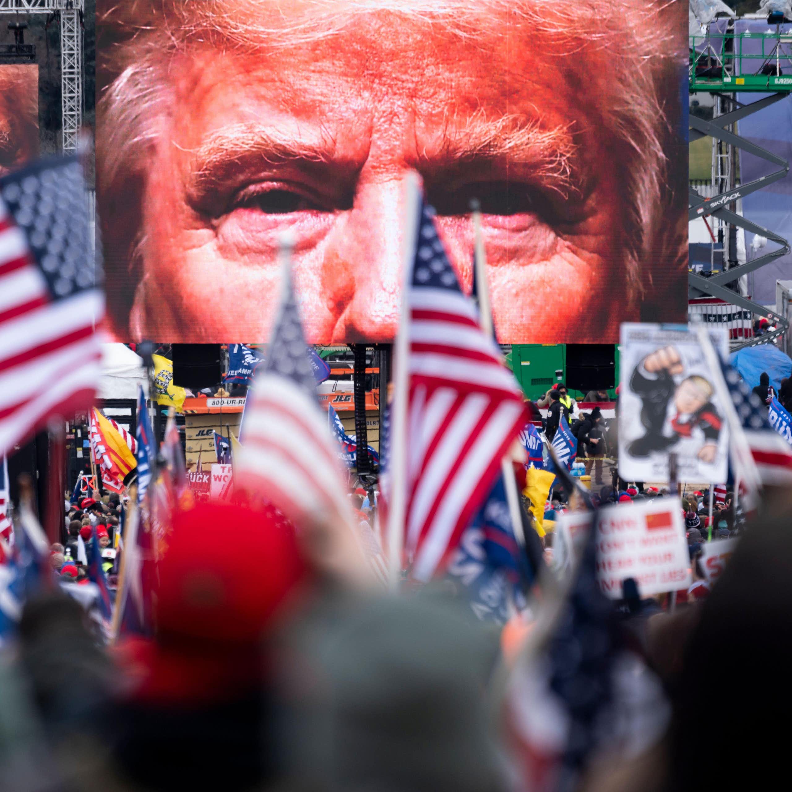 Trump supporters watch him on a big screen on January 6 2021. 