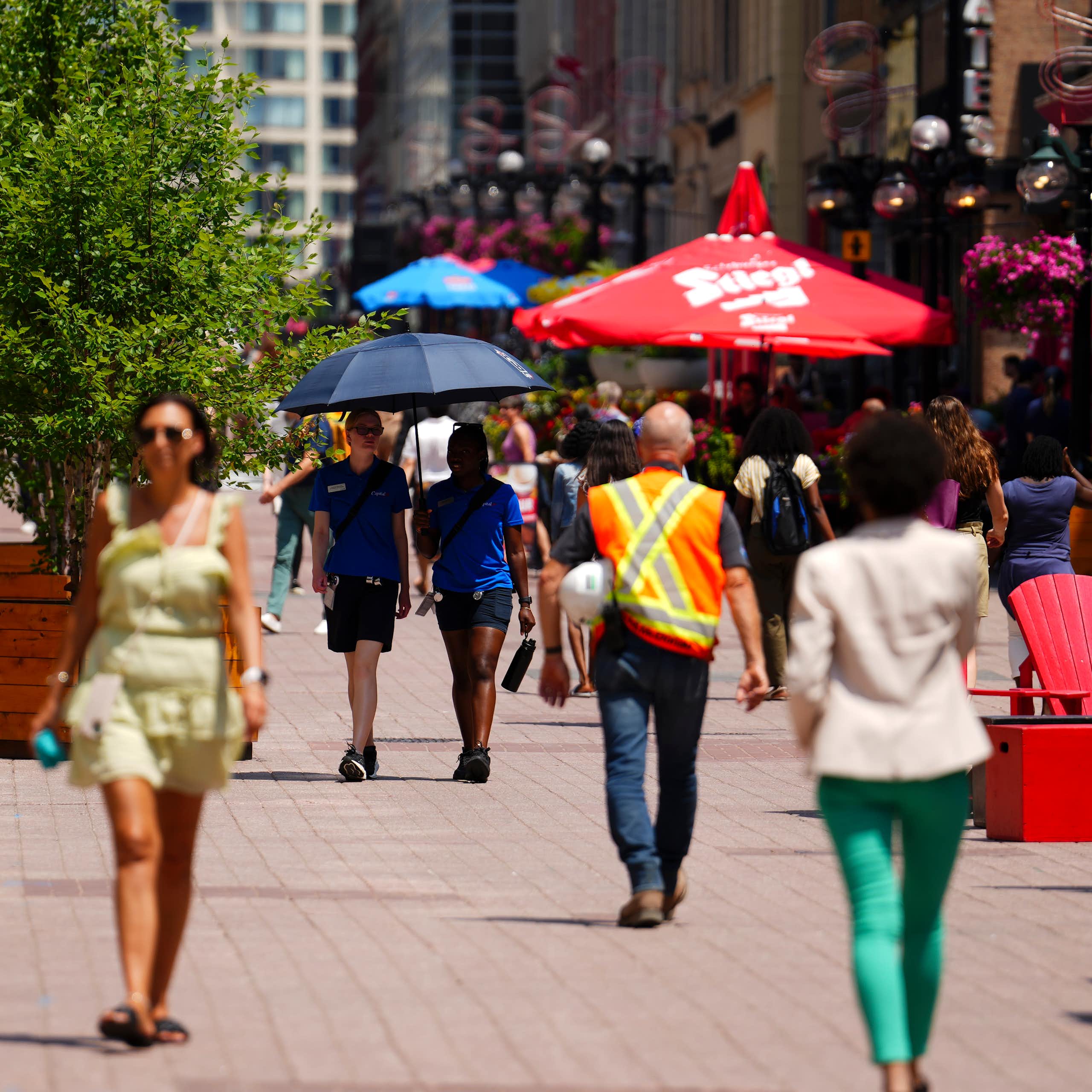 A group of people walk along a street.