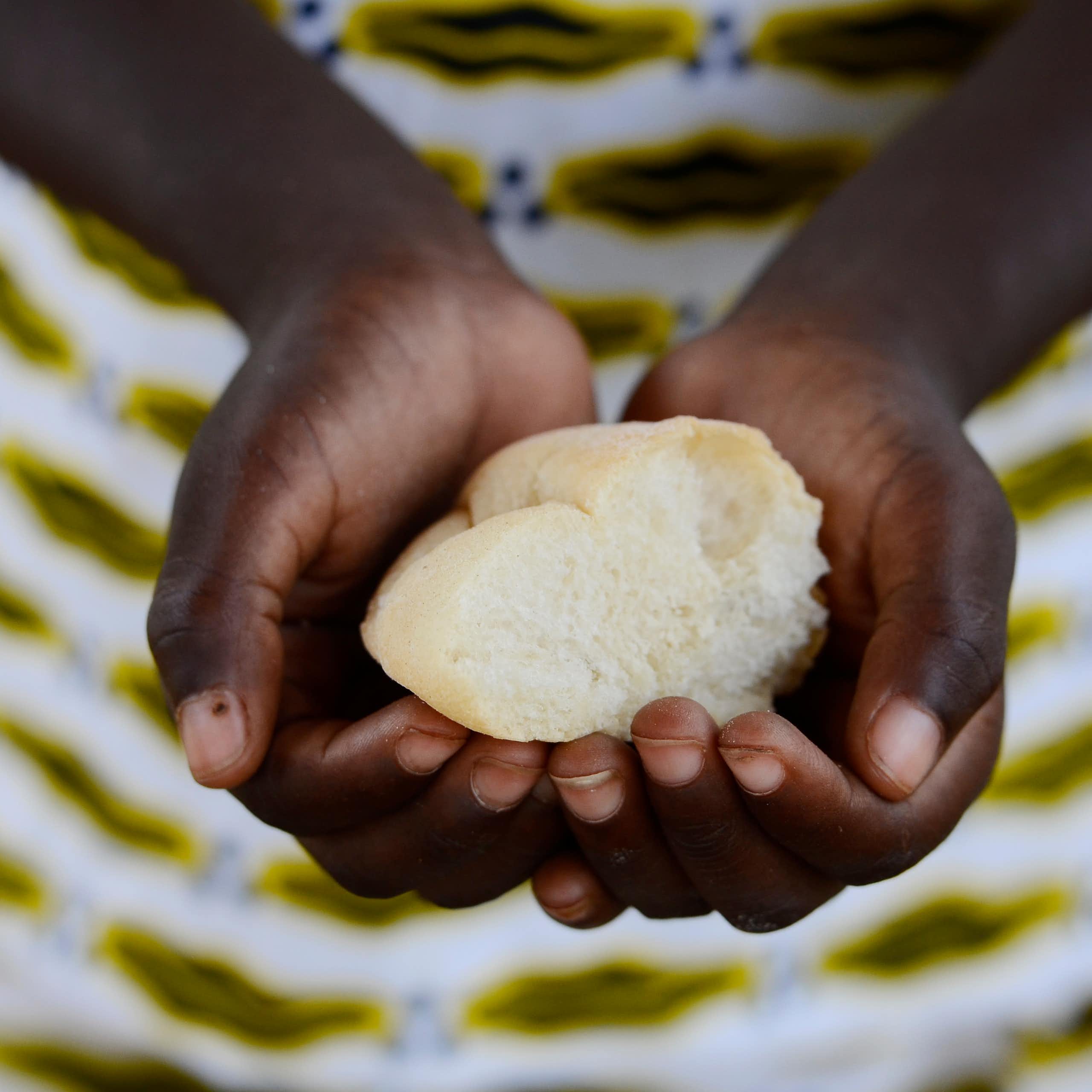 A child's hands holding a piece of bread
