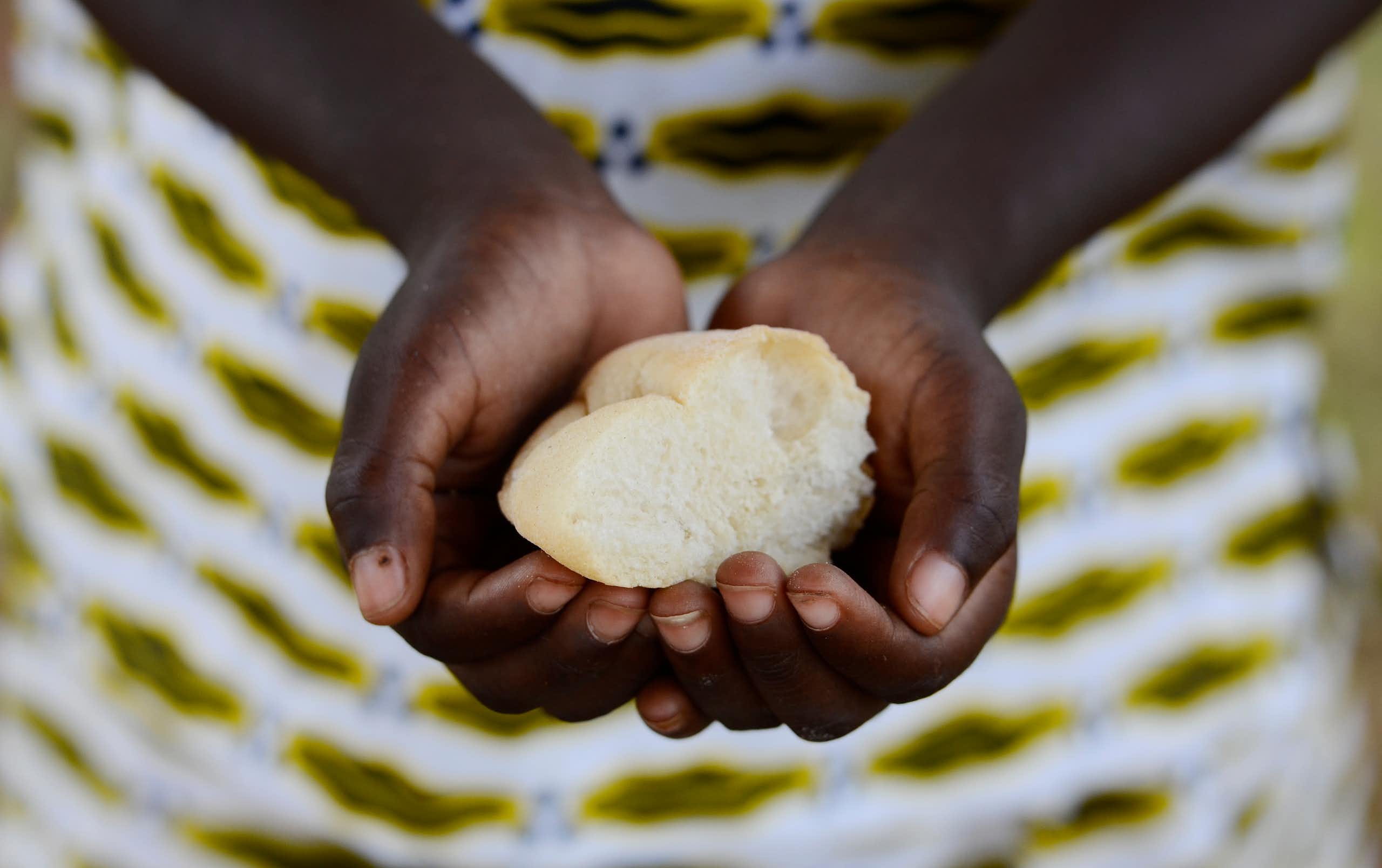 A child's hands holding a piece of bread