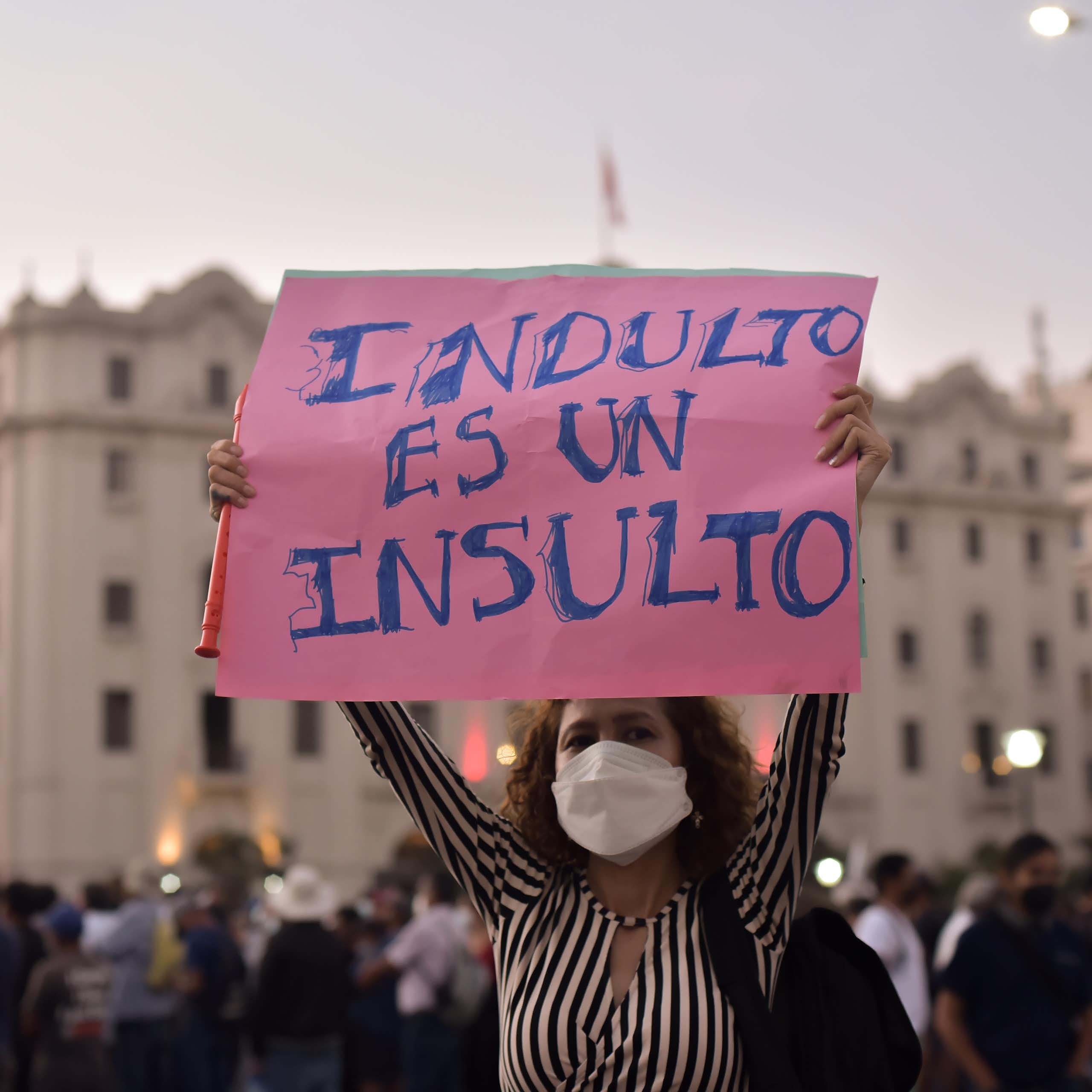 Mujer sostiene una pancarta en la que se lee: "Indulto es un insulto"