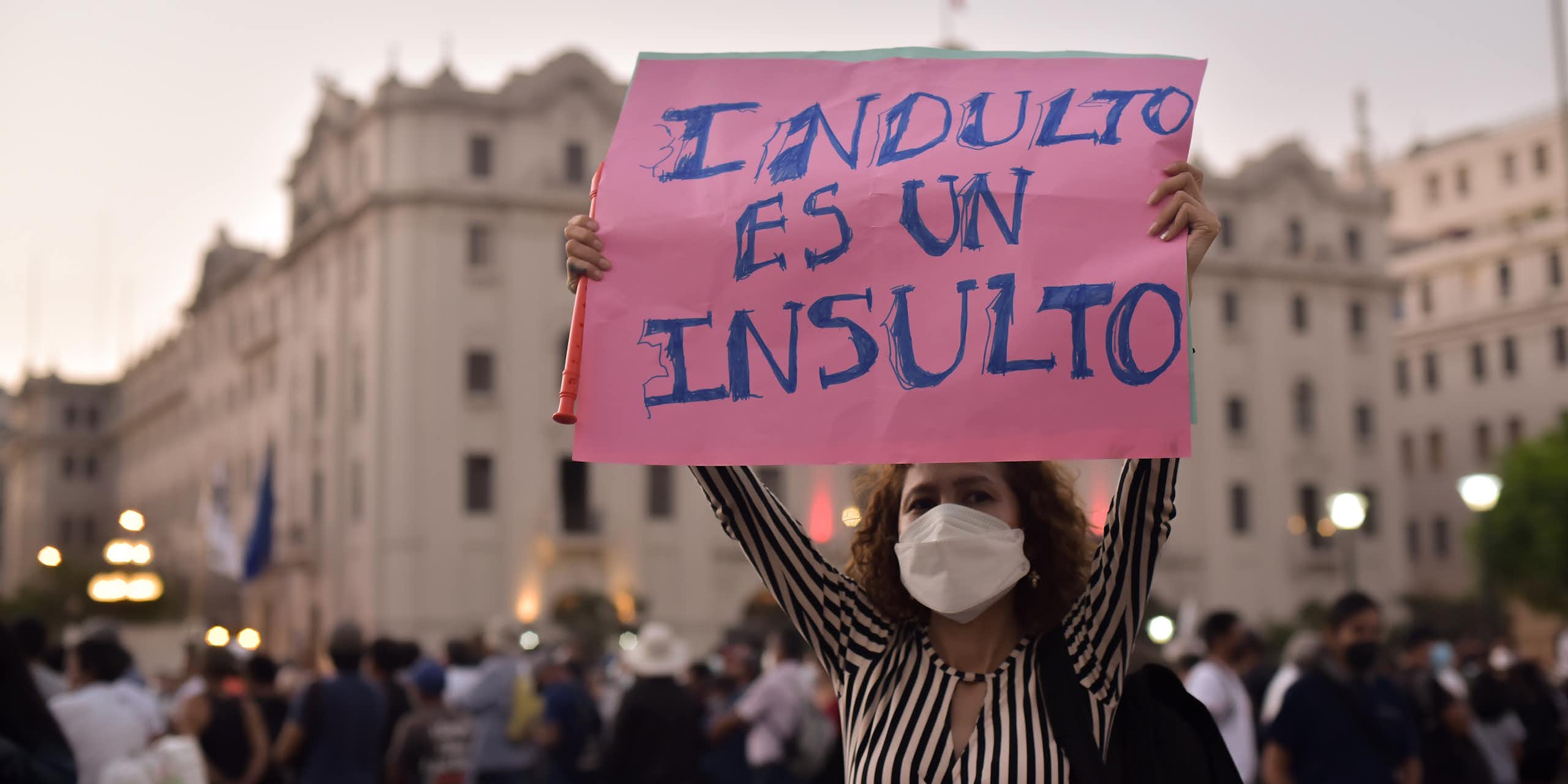 Mujer sostiene una pancarta en la que se lee: "Indulto es un insulto"