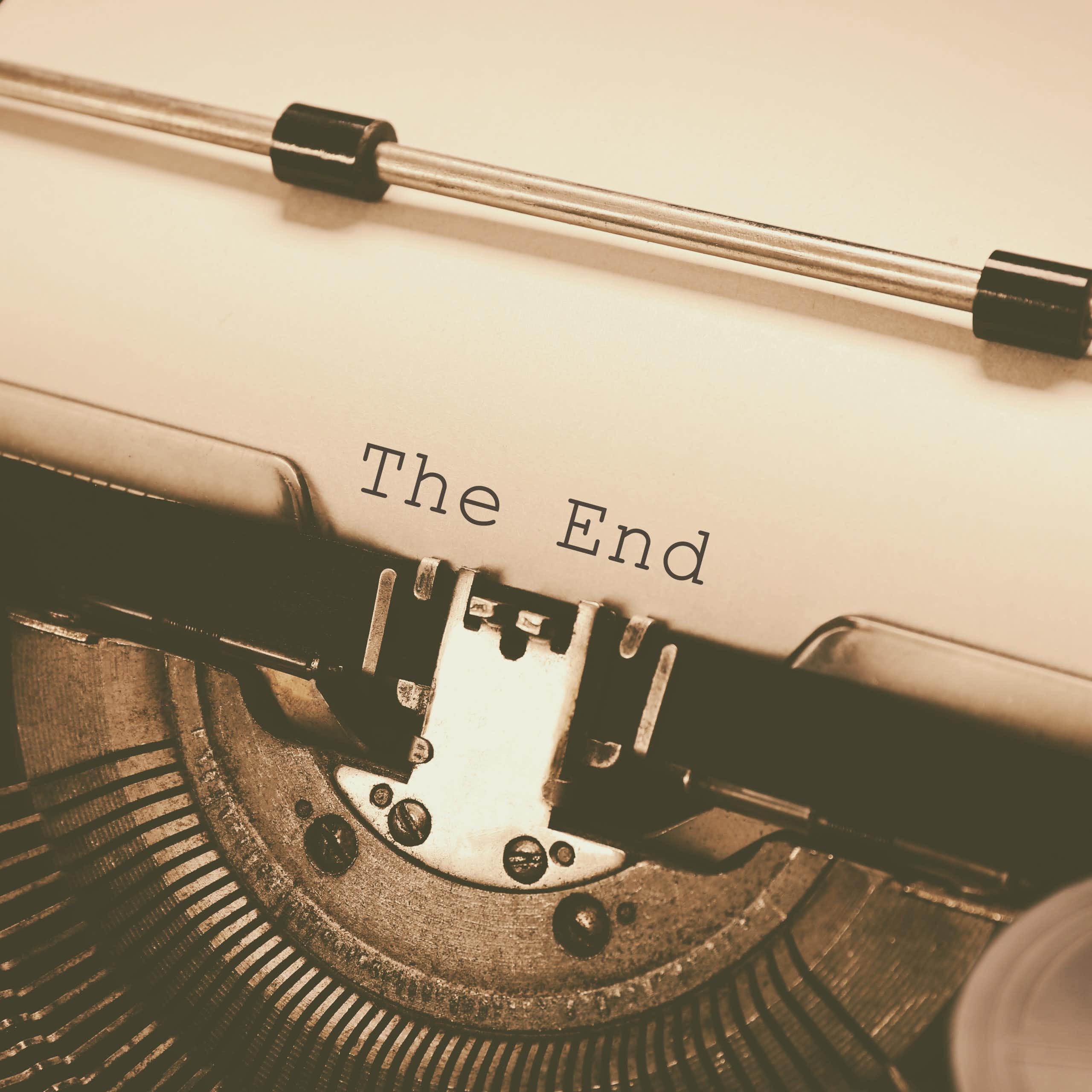 Uma velha máquina de datilografar com uma folha de papel onde se lê as palavras "The End" (fim)