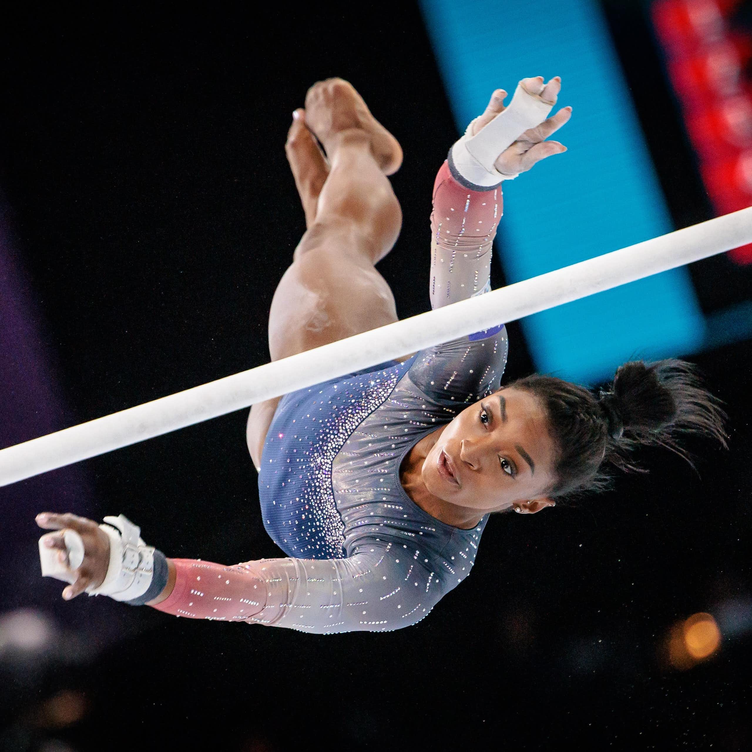 Simone Biles vuela sobre las barras asimétricas en los Mundiales de Gimnasia de Amberes en 2023.