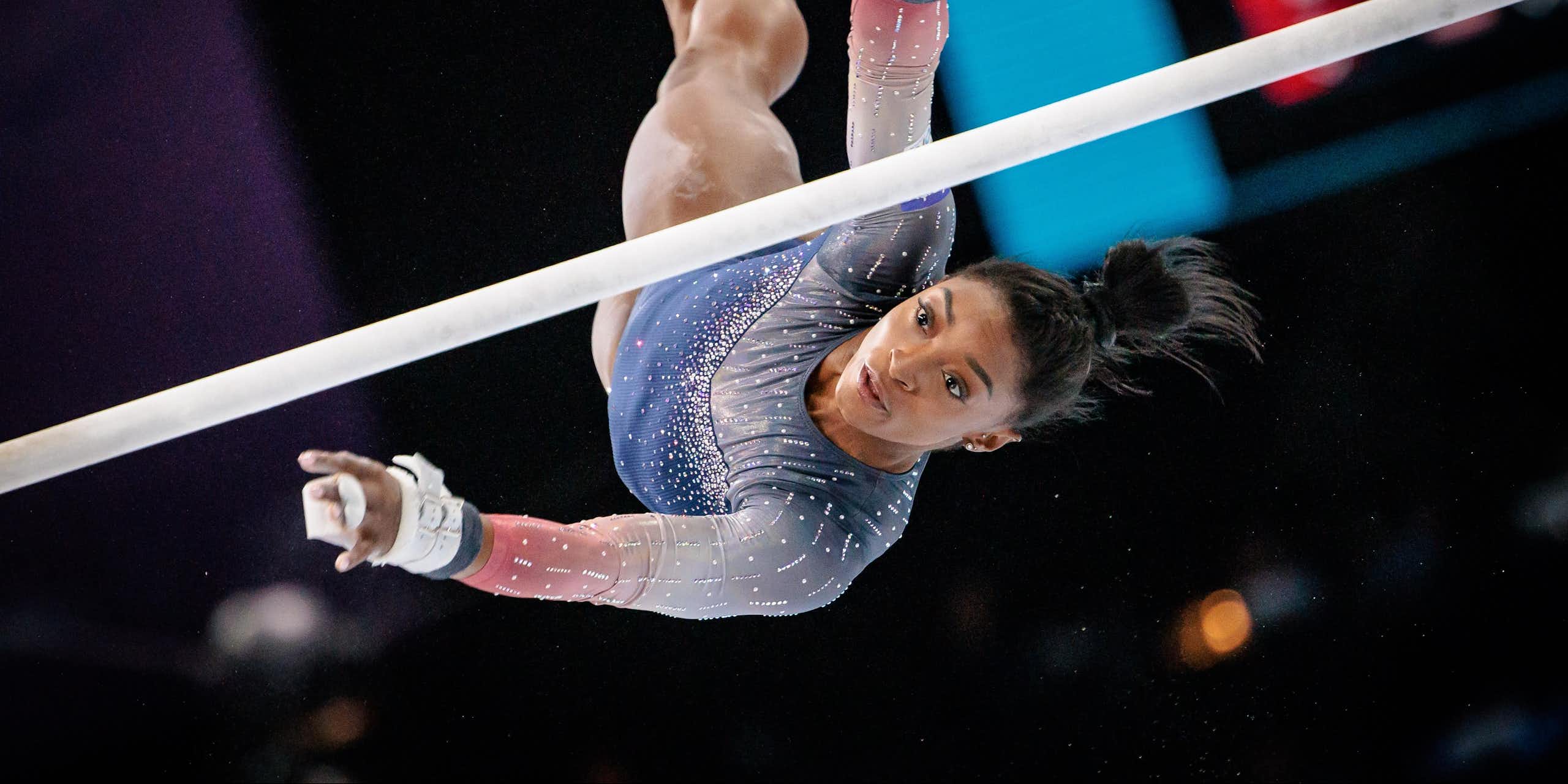 Simone Biles vuela sobre las barras asimétricas en los Mundiales de Gimnasia de Amberes en 2023.