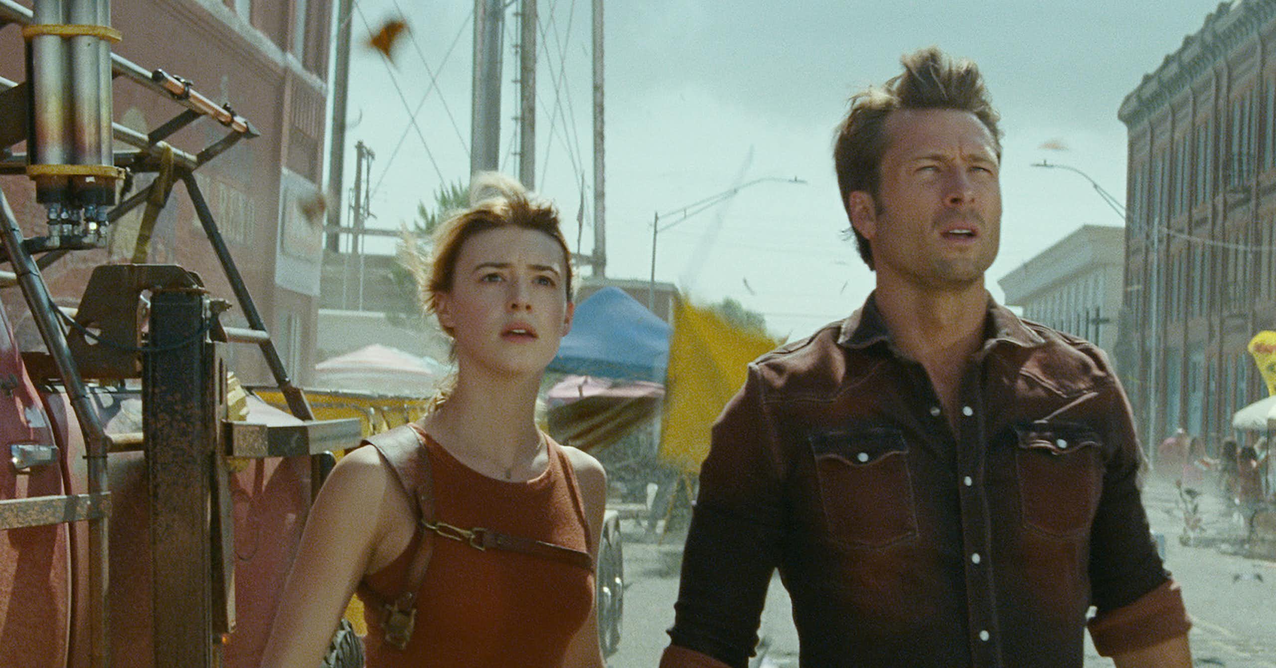 A woman and man look apprehensively at the sky.