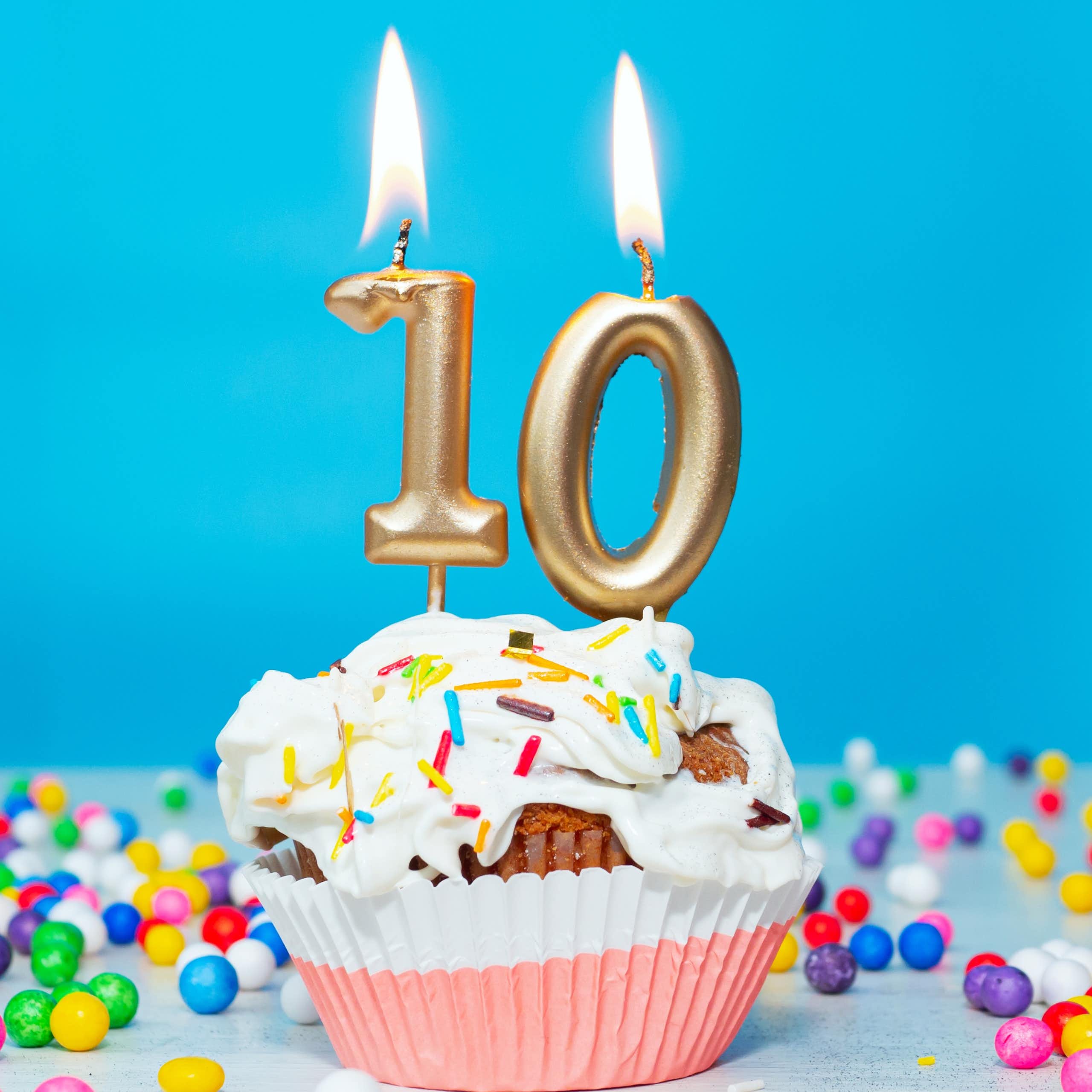 un gâteau d'anniversaire avec des bougies dorées indiquant le chiffre 10 