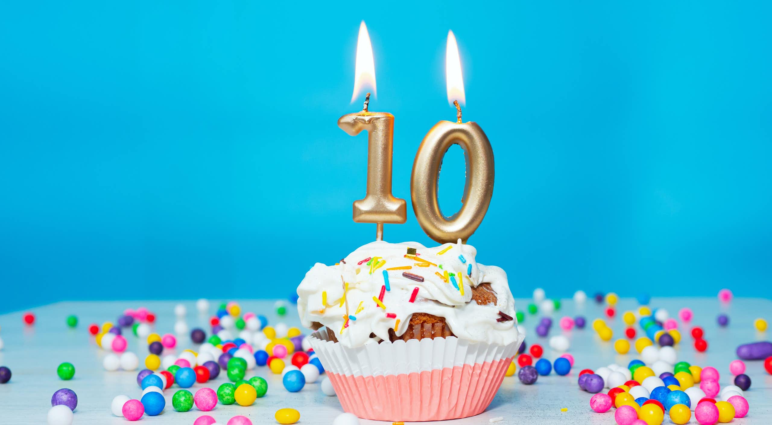 un gâteau d'anniversaire avec des bougies dorées indiquant le chiffre 10 
