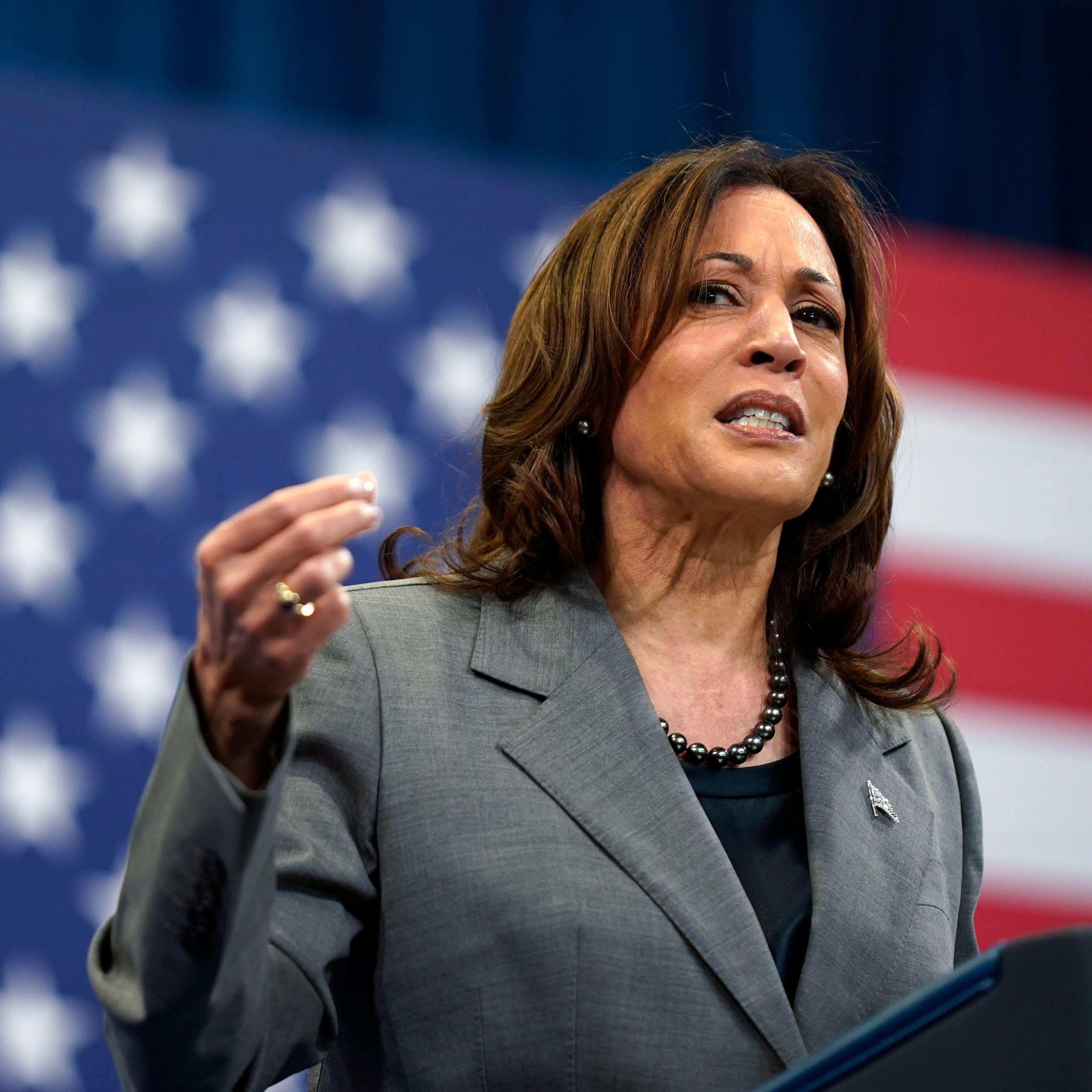 Kamala Harris at a podium in front of a US flag.