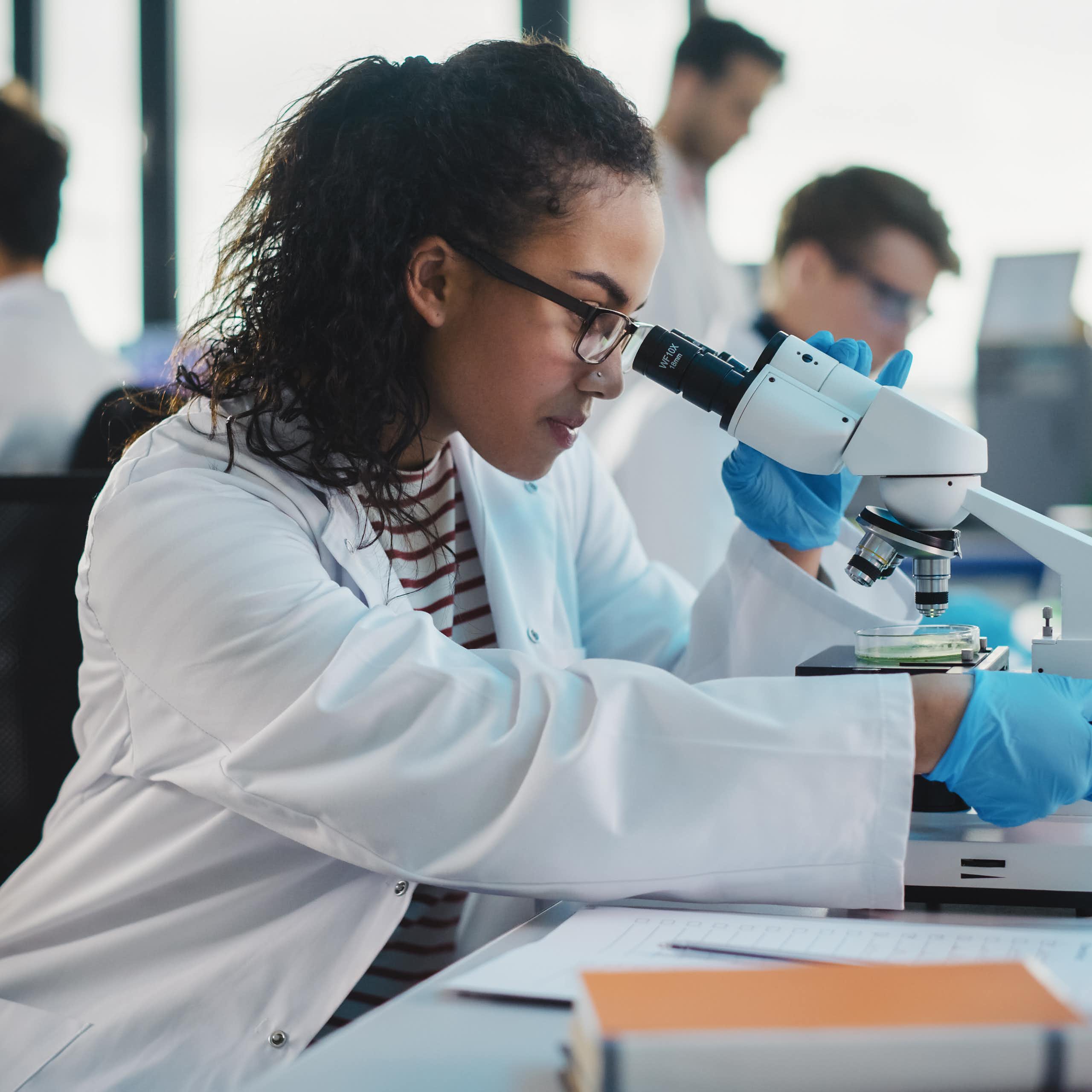 male and female scientists working in lab at microscopes