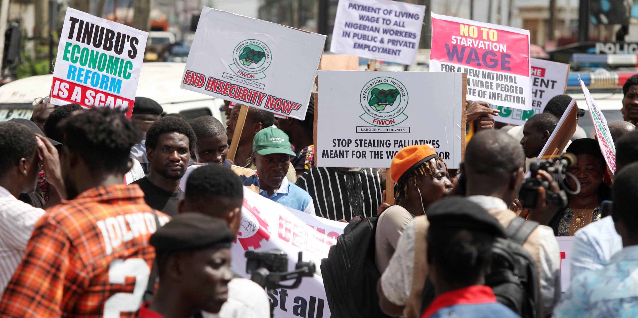 A group of people protesting on the street while holding placards