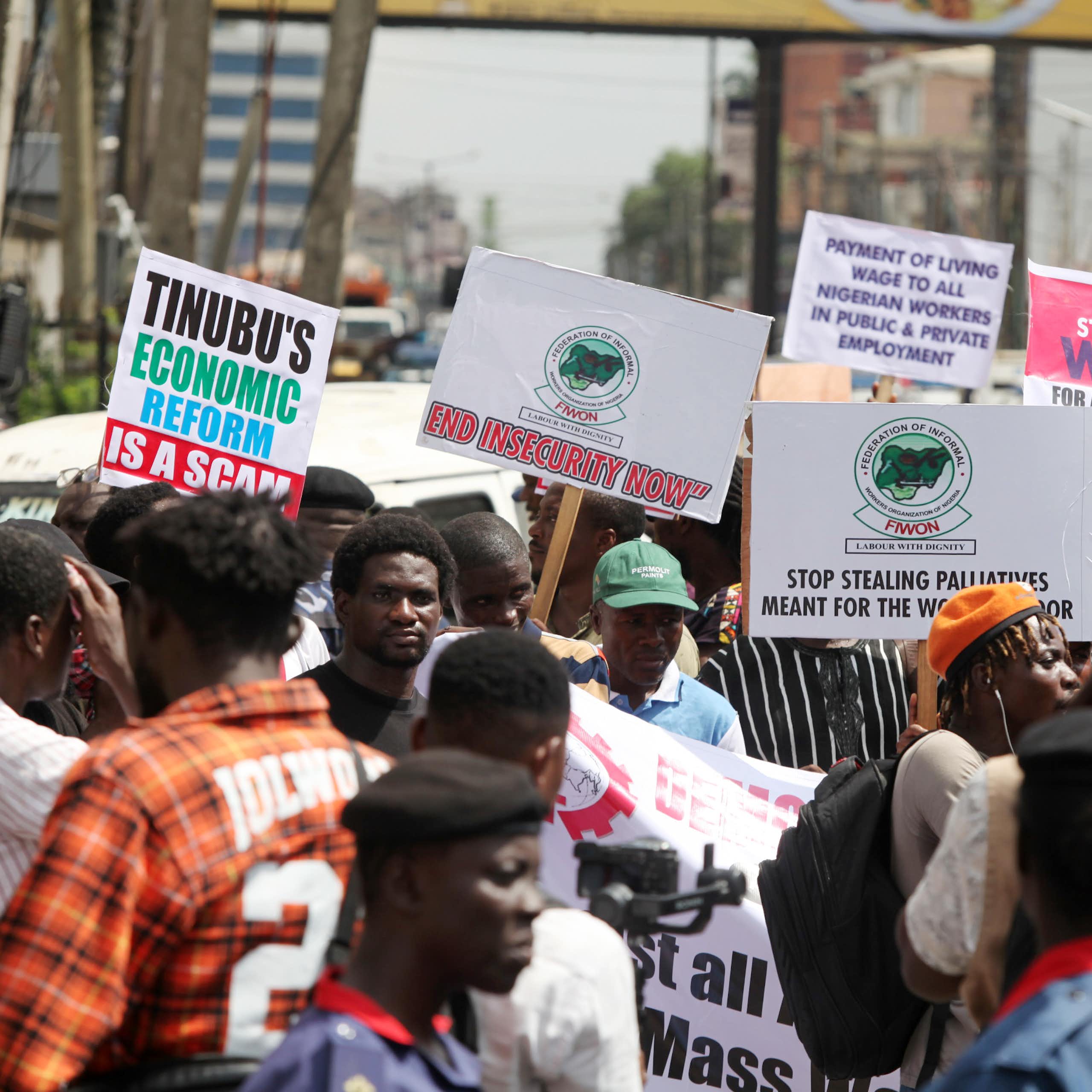 A group of people protesting on the street while holding placards