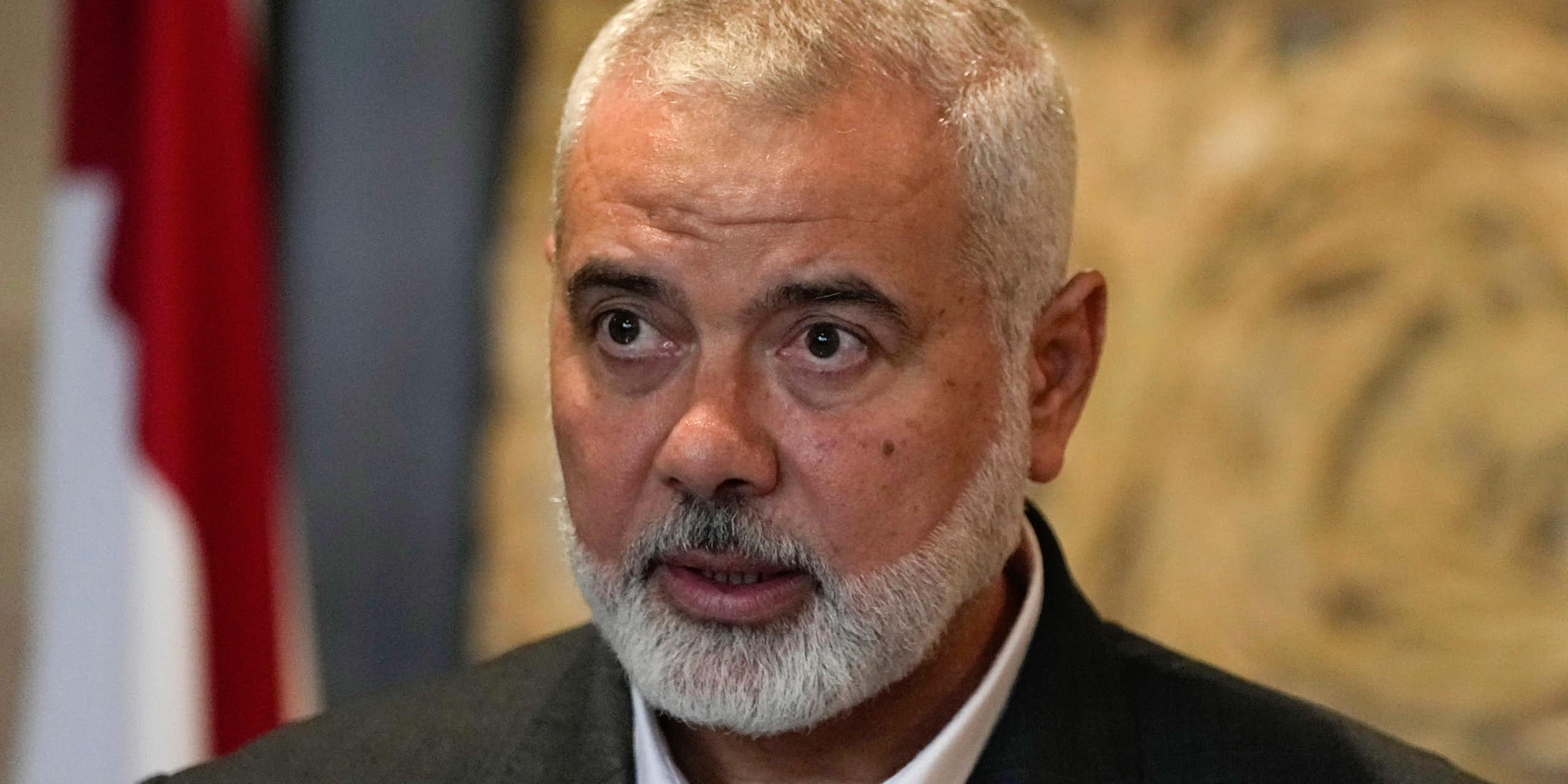 A man in a suit jacket looks past the camera