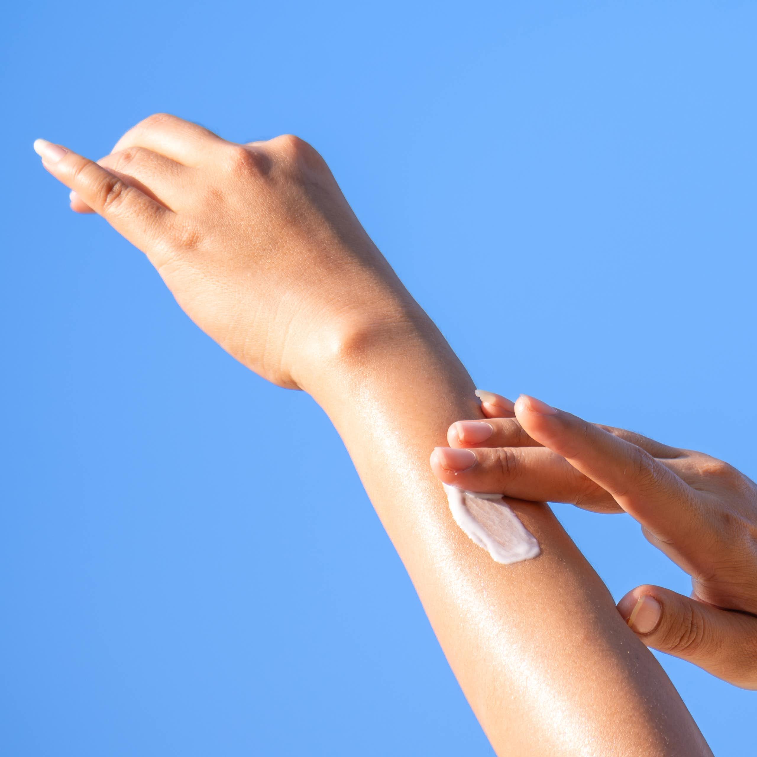 Gros plan d'une femme se passant de la crème solaire.