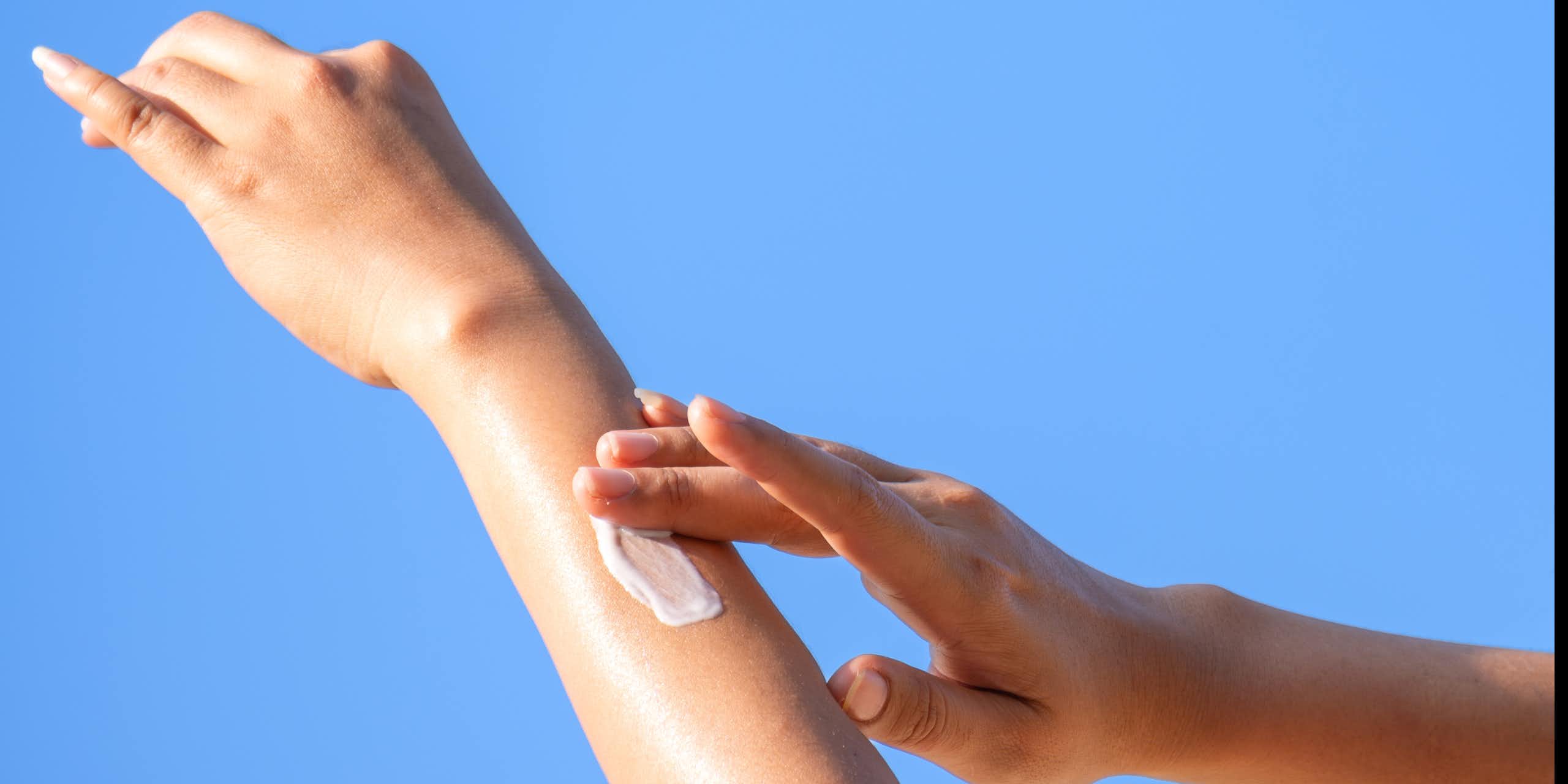 Gros plan d'une femme se passant de la crème solaire.